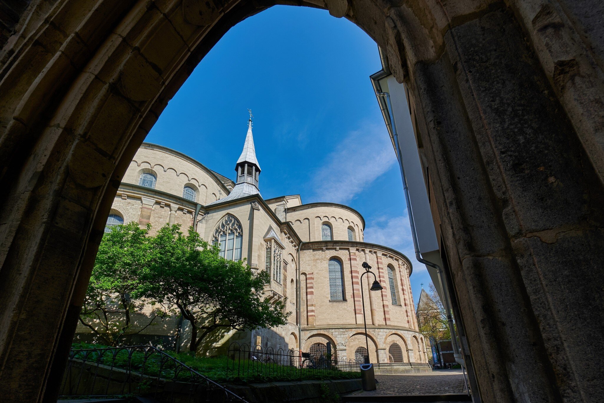 The view through the historic Dreikoenigenpfoertchen (Three Kings Gate) toward the Basilica of St. Maria im Kapitol in Cologne, Germany.