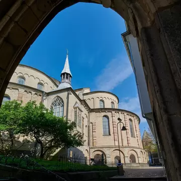The view through the historic Dreikoenigenpfoertchen (Three Kings Gate) toward the Basilica of St. Maria im Kapitol in Cologne, Germany.