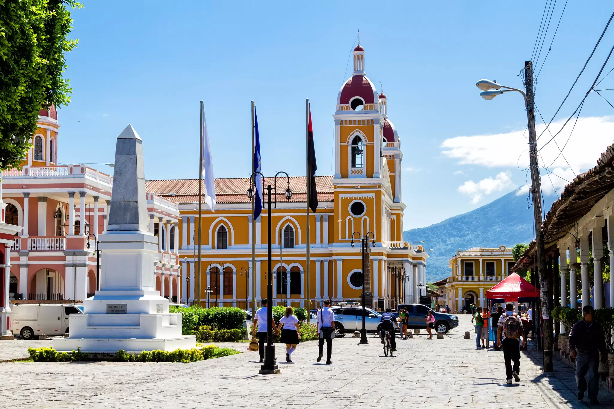 A large cathedral painted white and orange that sits on the edge of a city plaza.