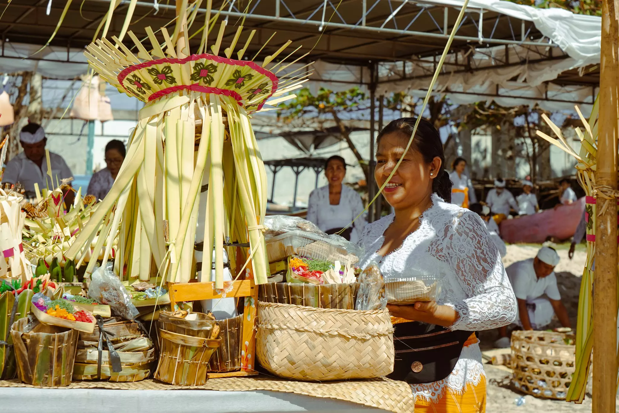 A vender at a stall with items in woven bamboo.
