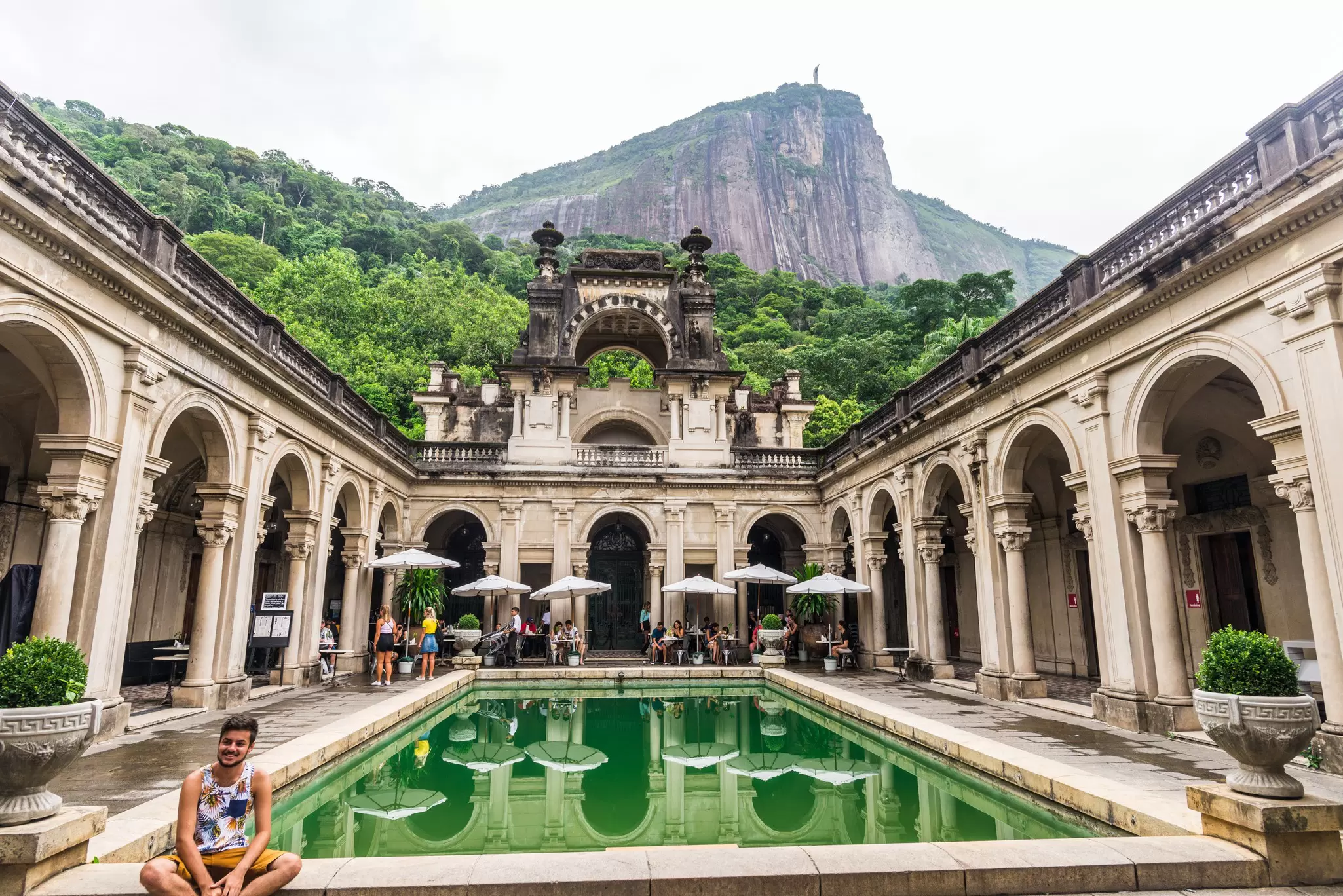 A visitor sits by the pool at the famous mansion in Parque Lage in Rio de Janeiro, Brazil.