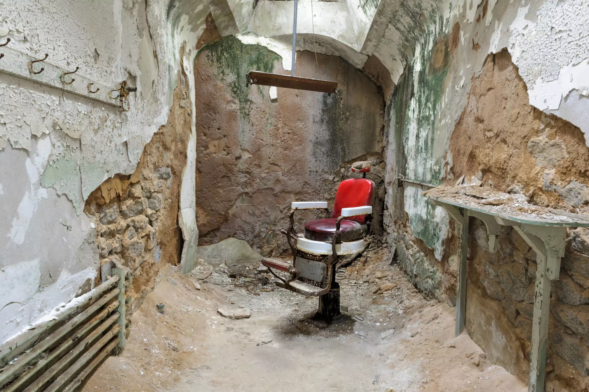 A barber chair sits in a decaying prison cell at Eastern State Penitentiary in Philadelphia