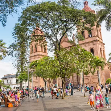 People relax ina city square in front of a cathedral