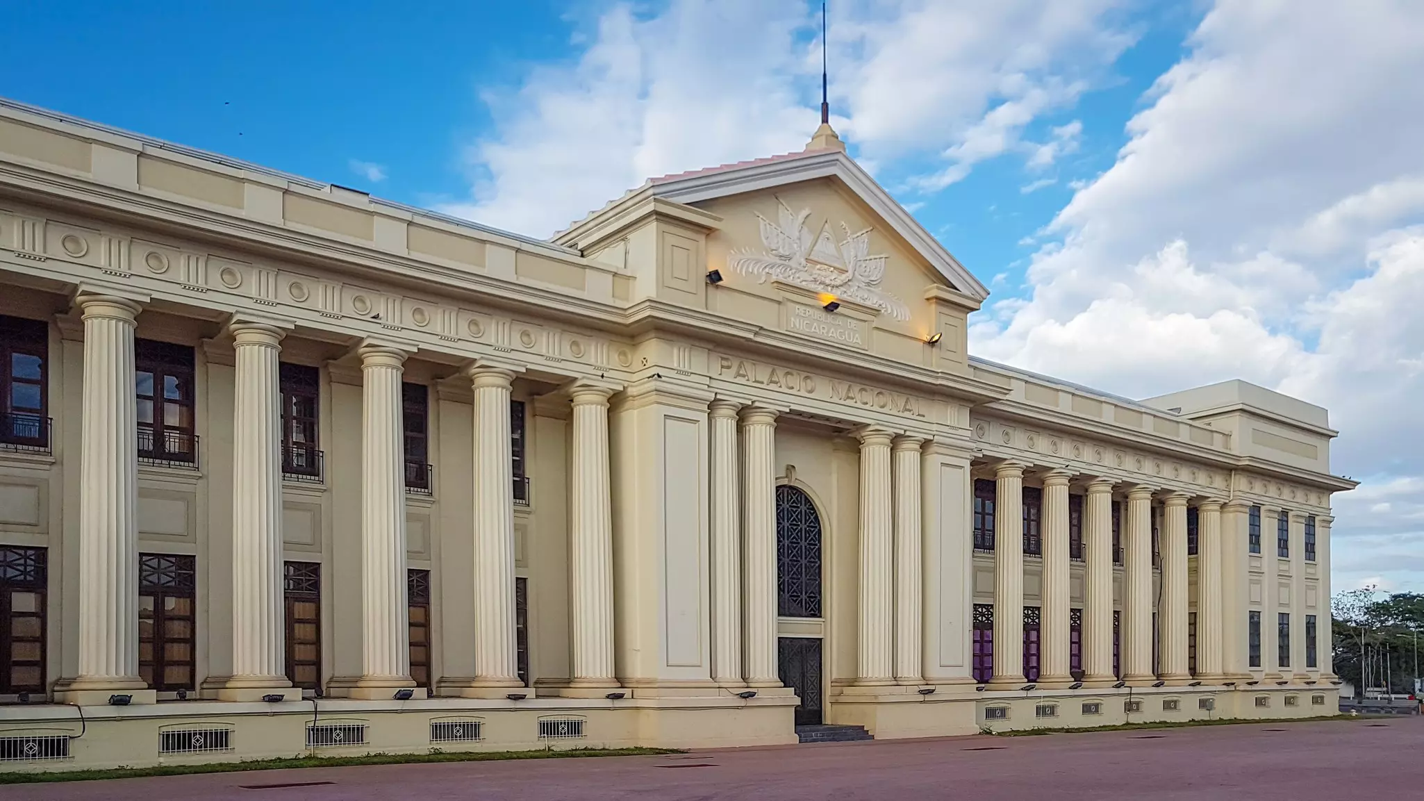 A large building with columns along its facade. "Palacio Nacional" is carved into the building, over the entrance.