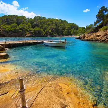 View of a boat in the water in Cala Mastella on the island of Ibiza in Spain.