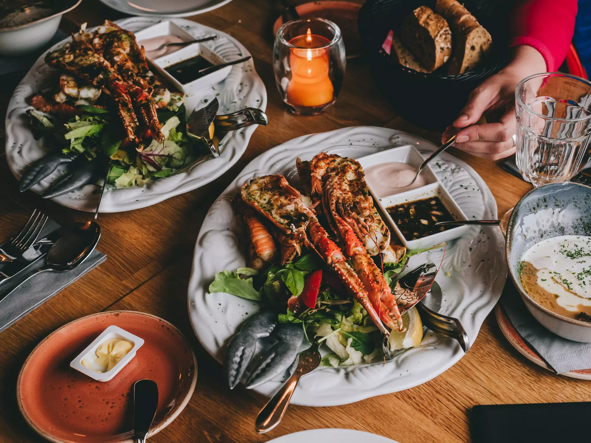 Large langoustines served with sauces on a bed of salad