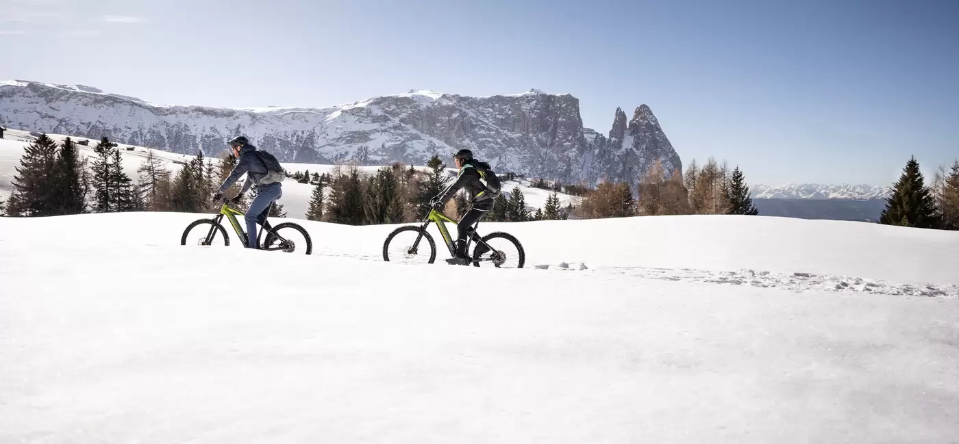 Bikers pedaling through snow: COMO Hotels & Resorts, the Dolomites, Italy