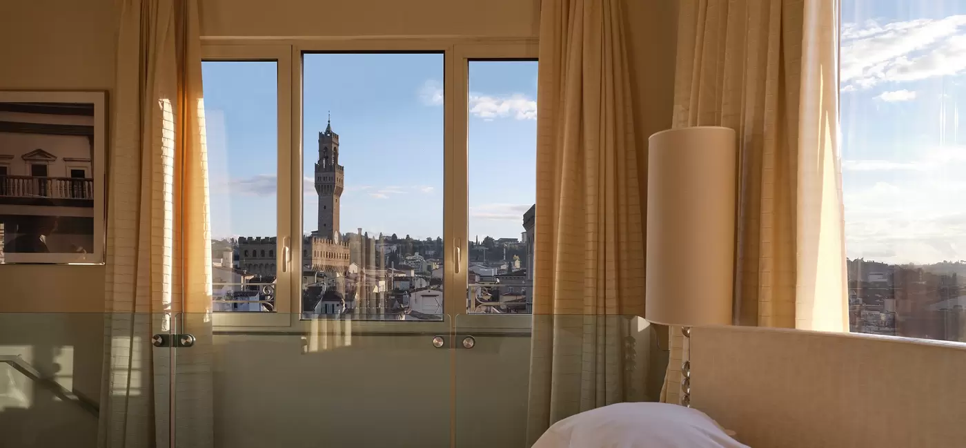 View from the side of a bed with windows behind it of Florence's skyline - lots of renaissance architecture