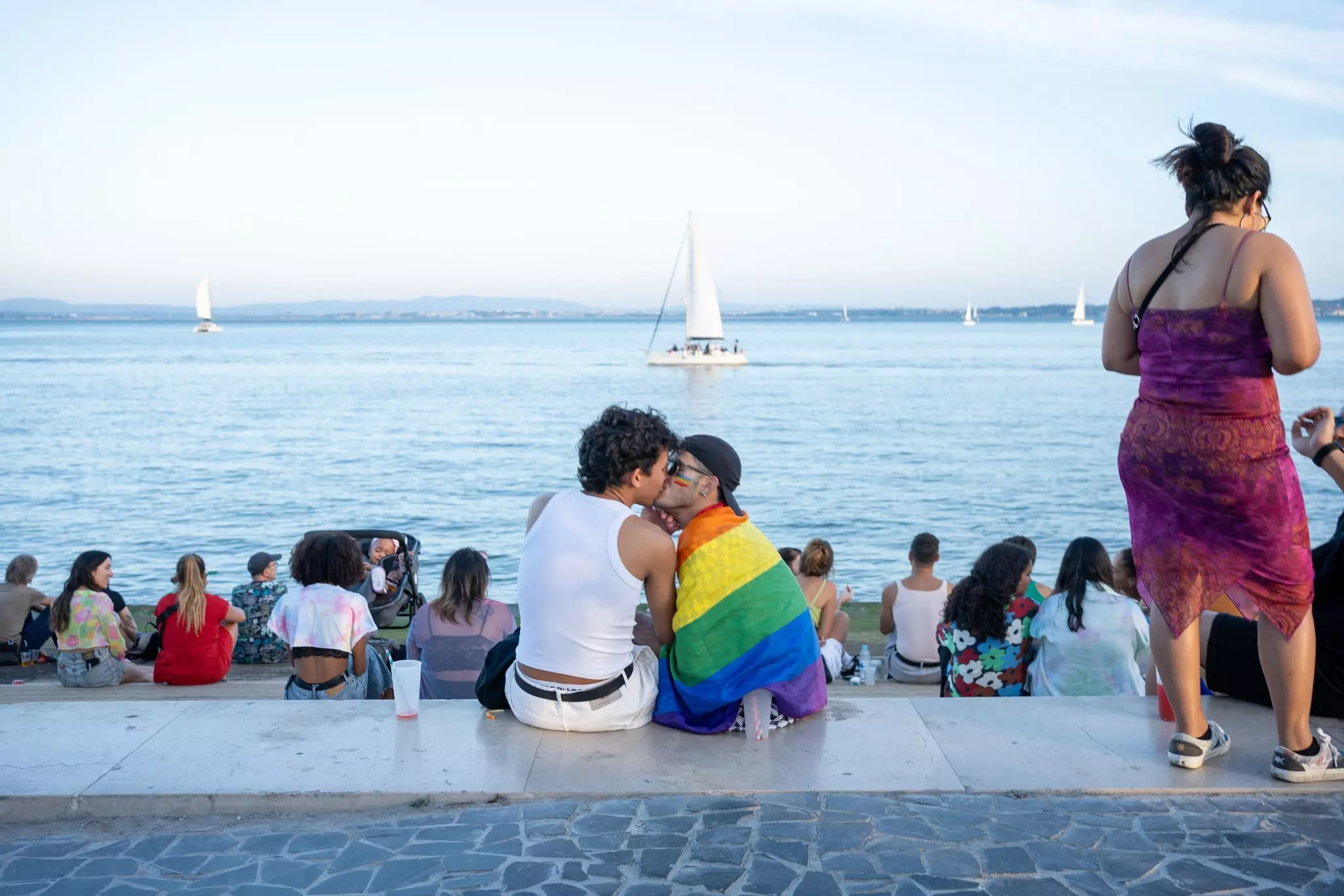 A couple embracing next to the waterfront during Lisbon's Pride festival