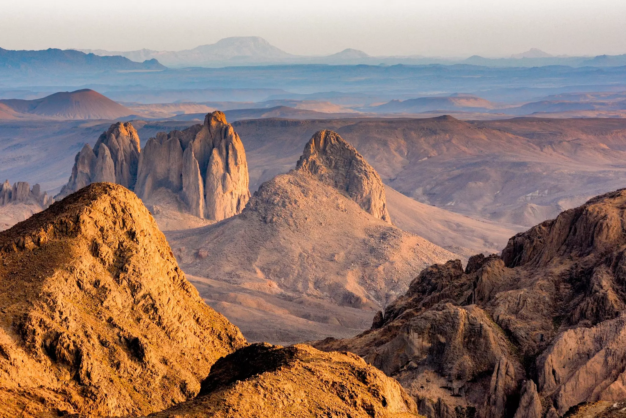 Rocky desert landscape bathed in the sunlight and glowing in browns and oranges.