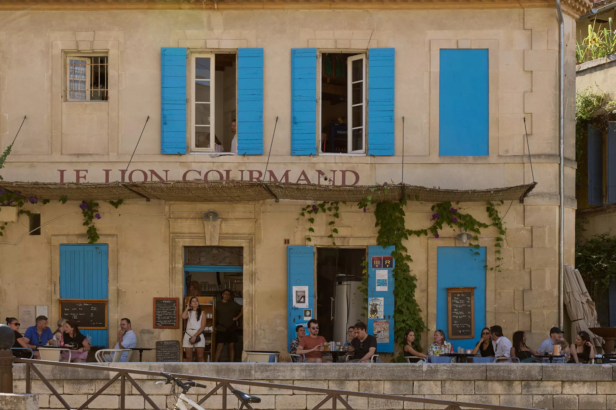 People dining outside on a restaurant's terrace in Arles. 
