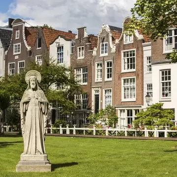 View of a statue on a lawn in Begijnhof, Amsterdam, on a sunny day.