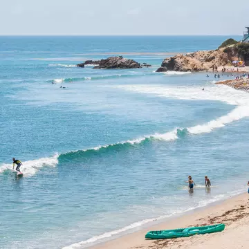 Surfers, swimmers and sunbathers on a summer day in southern California. ©David M. Schrader/Shutterstock