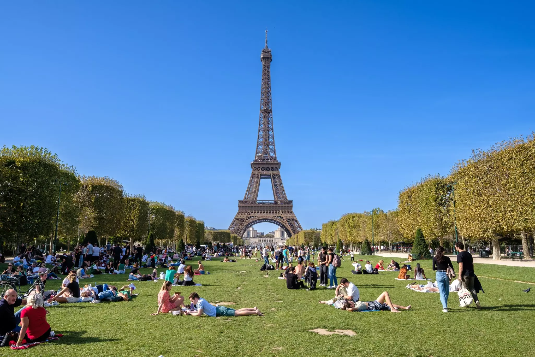 Panoramic view of the Champ de Mars, Field of Mars, a large public greenspace with people in Paris France