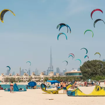 April 16th 2021, Dubai UAE, An aerial shot of Kite Beach in Dubai filled with kite surfers and their colorful kites flying in the air or being prepared on the ground, License Type: media, Download Time: 2026-05-27T21:30:52.000Z, User: lonelyplanetmedia, Editorial: true, purchase_order: 65050 - Digital Destinations and Articles, job: Comp Ingestion, client: Global Publishing WIP, other: Pia Peterson
