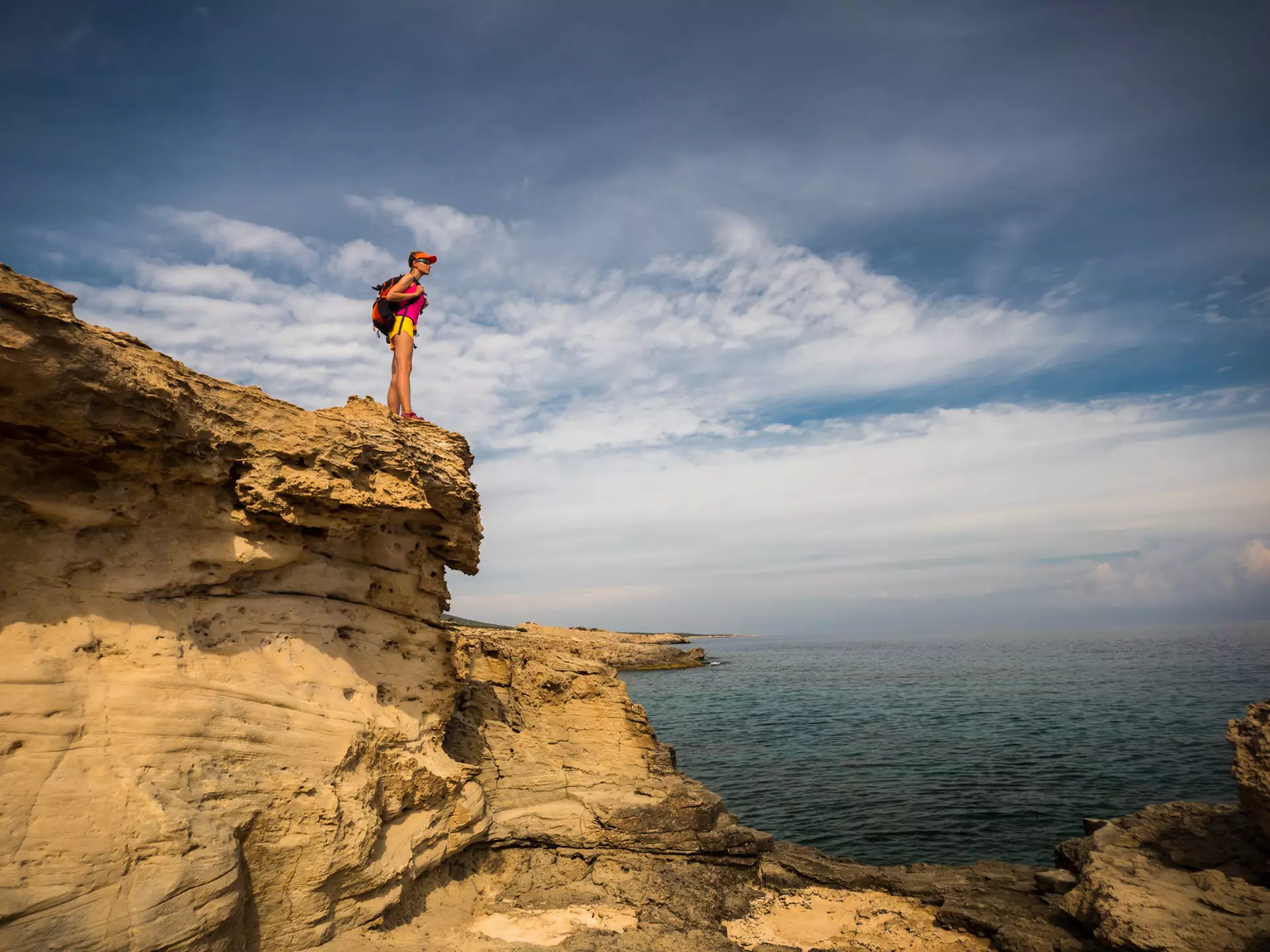 A women hiker on a rocky shoreline in the Akamas Peninsula, Cyprus