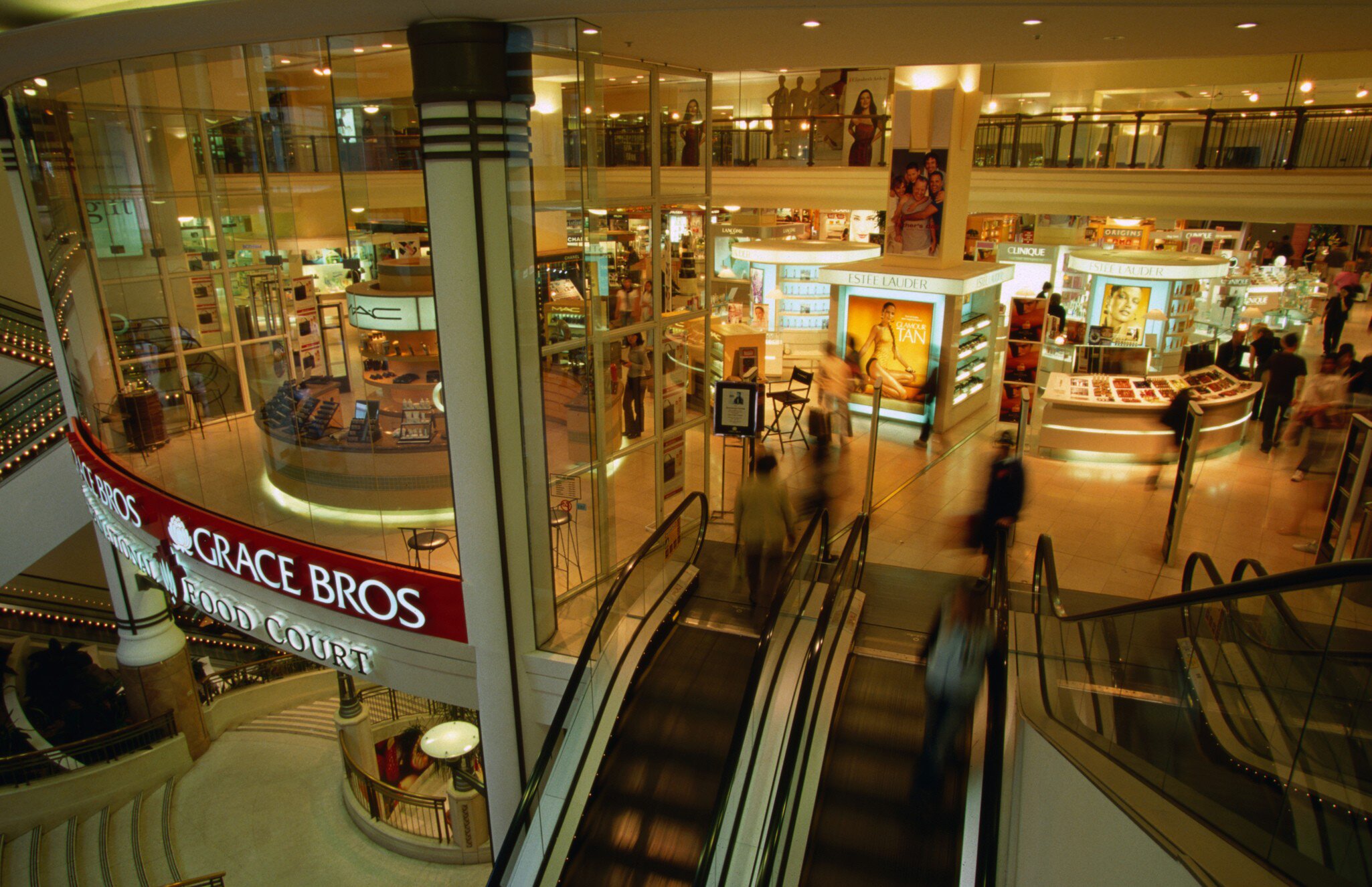 Overhead view of shoppers and an escalator inside Pitt St mall. Sydney, Australia.