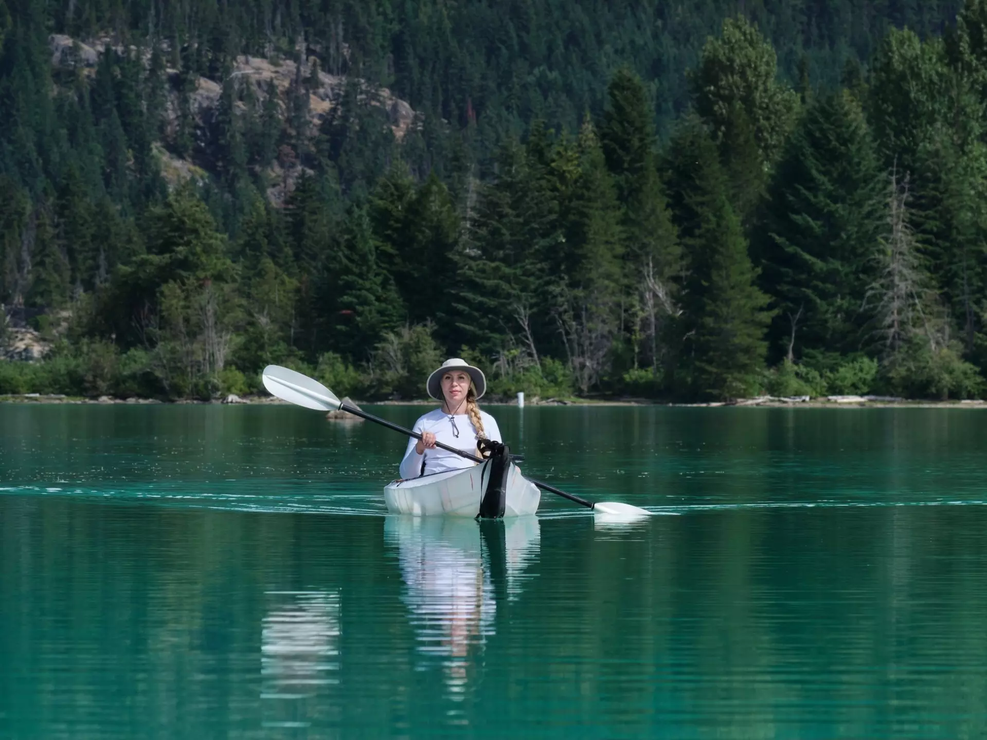 Woman in foldable kayak paddling  in calm lake with reflections. Green lake. Whistler. British Columbia. Canada, License Type: media, Download Time: 2025-12-05T00:01:59.000Z, User: catalinaaragon, Editorial: false, purchase_order: 56530 - Guidebooks, job: Global Publishing WIP, client: Canada 17, other: Lonely Planet
