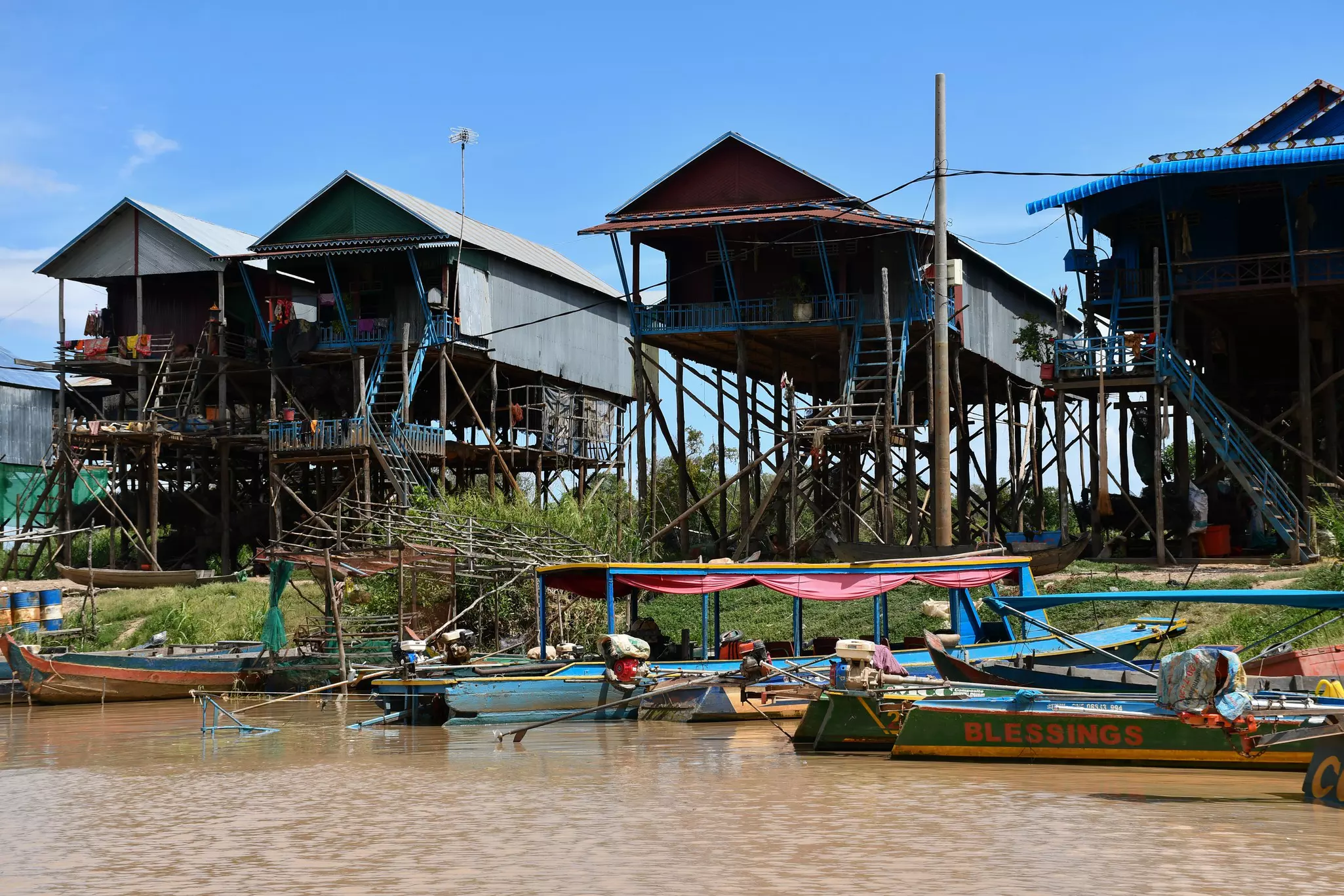 Houses built on stilts and fishing boats on the Tahas River in the floating village of Kampong Pluk, Camodia.