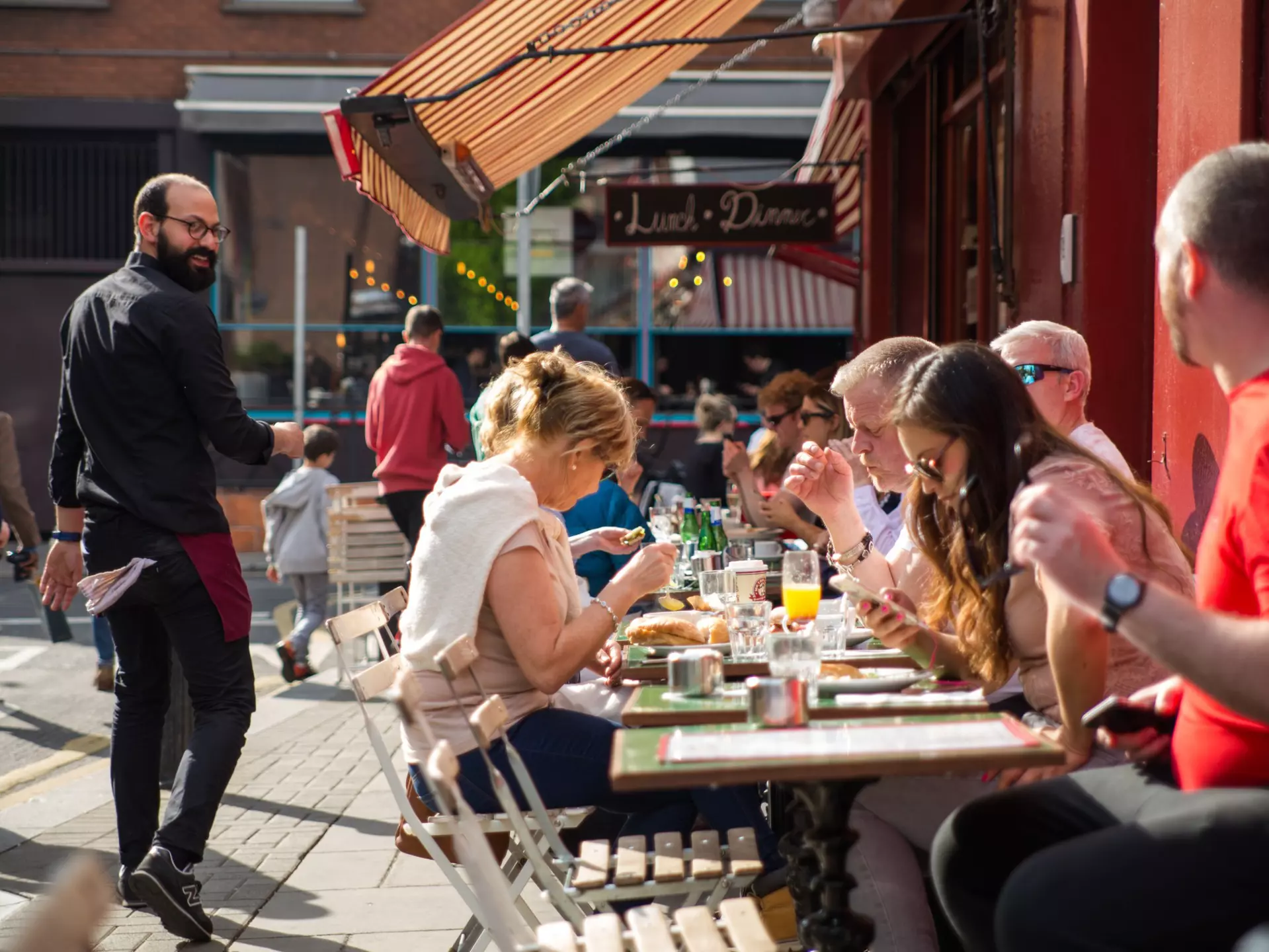 People dining outdoors on a sunny day at a pub in Dublin.