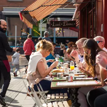 People dining outdoors on a sunny day at a pub in Dublin.