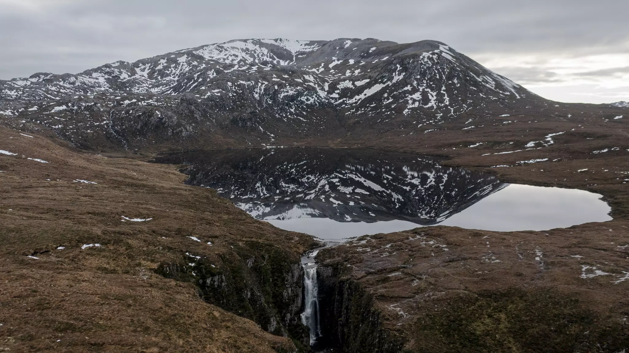 Views around the Allt Chranaidh Waterfall, with a gray sky above