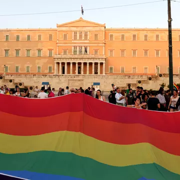 A huge rainbow flag in front of the Greek Parliament during the annual Pride parade. Kostas Koutsaftikis / Shutterstock