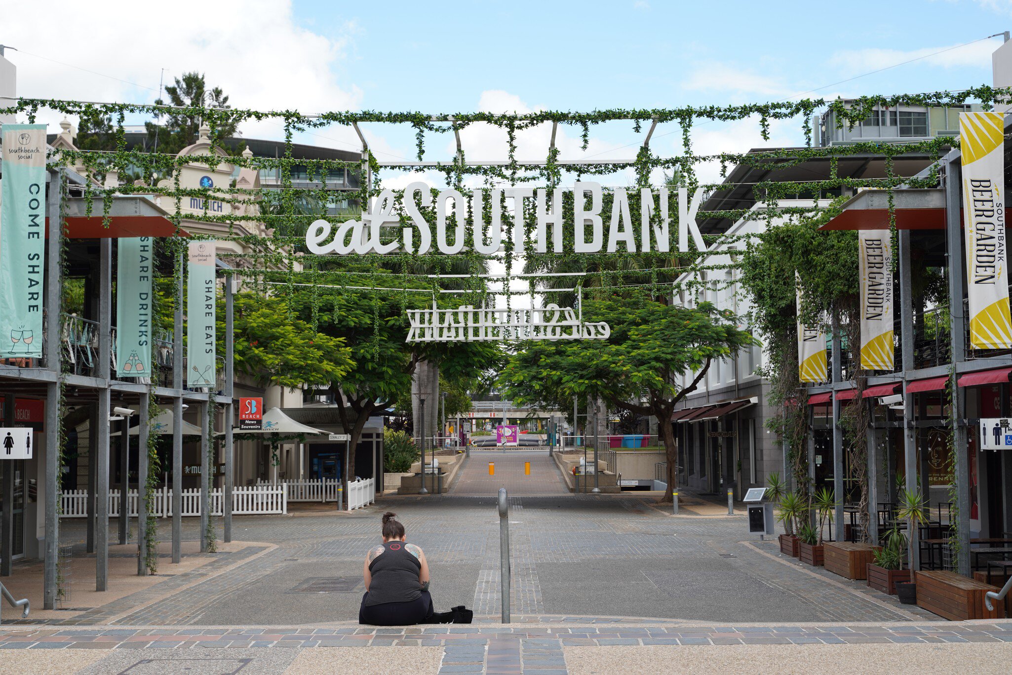  A single person sitting at the Stanley Street Plaza in South Bank Parklands. Brisbane, Australia.