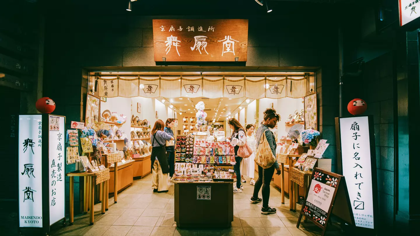 People browse around a shop with signs in Japanese and English outside it