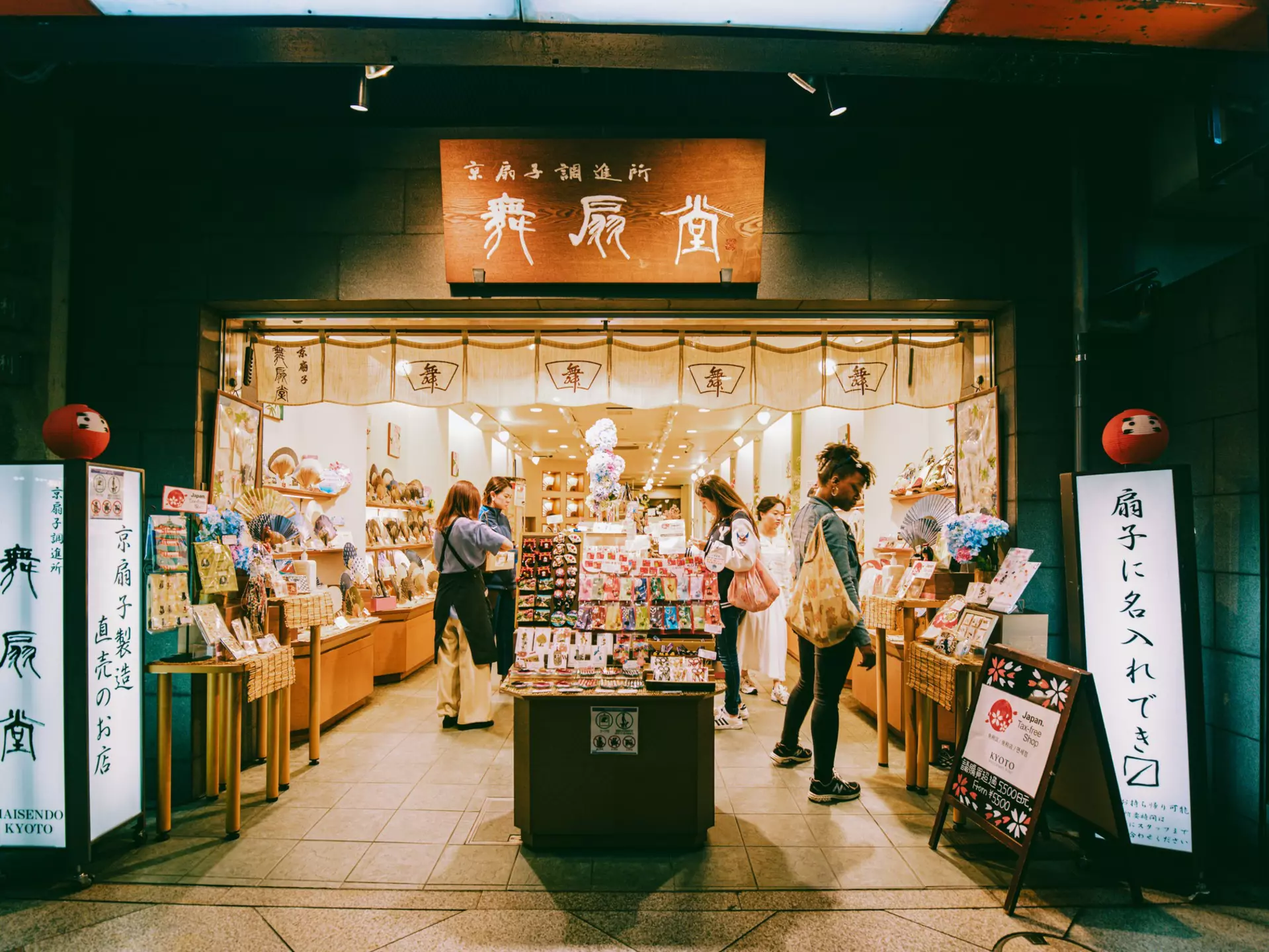 People browse around a shop with signs in Japanese and English outside it