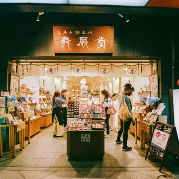 People browse around a shop with signs in Japanese and English outside it