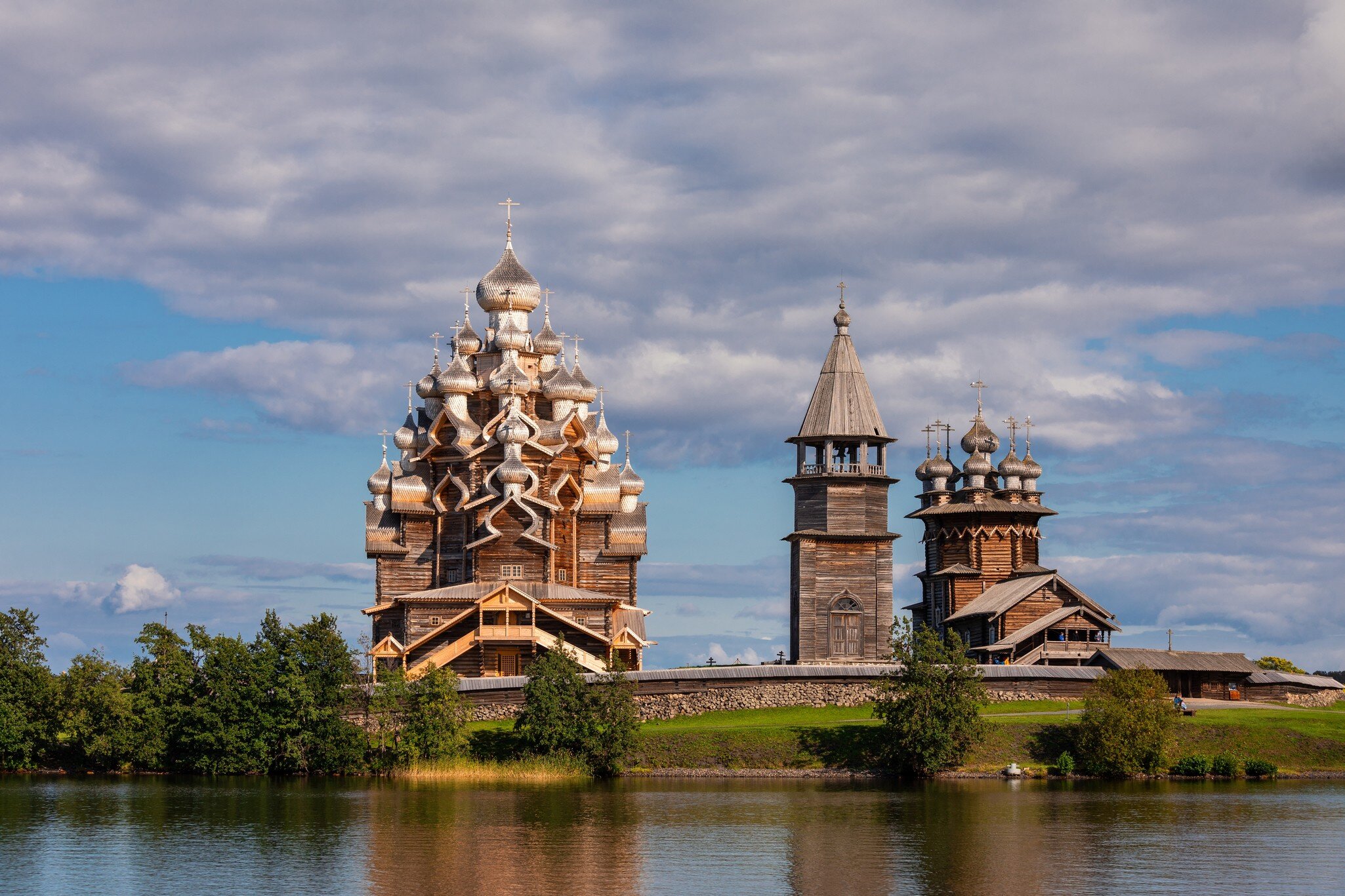 Kizhi, Russia - 13 Aug 2020: 17th-century wooden churches and bell tower of Kizhi Pogost historical site, listed as UNESCO World Heritage Site and one of the most popular tourist destinations in Republic of Karelia
