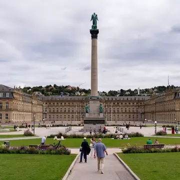 People walking towards the Neues Schloss with Jubilee Column at Schlossplatz in Stuttgart, Germany.