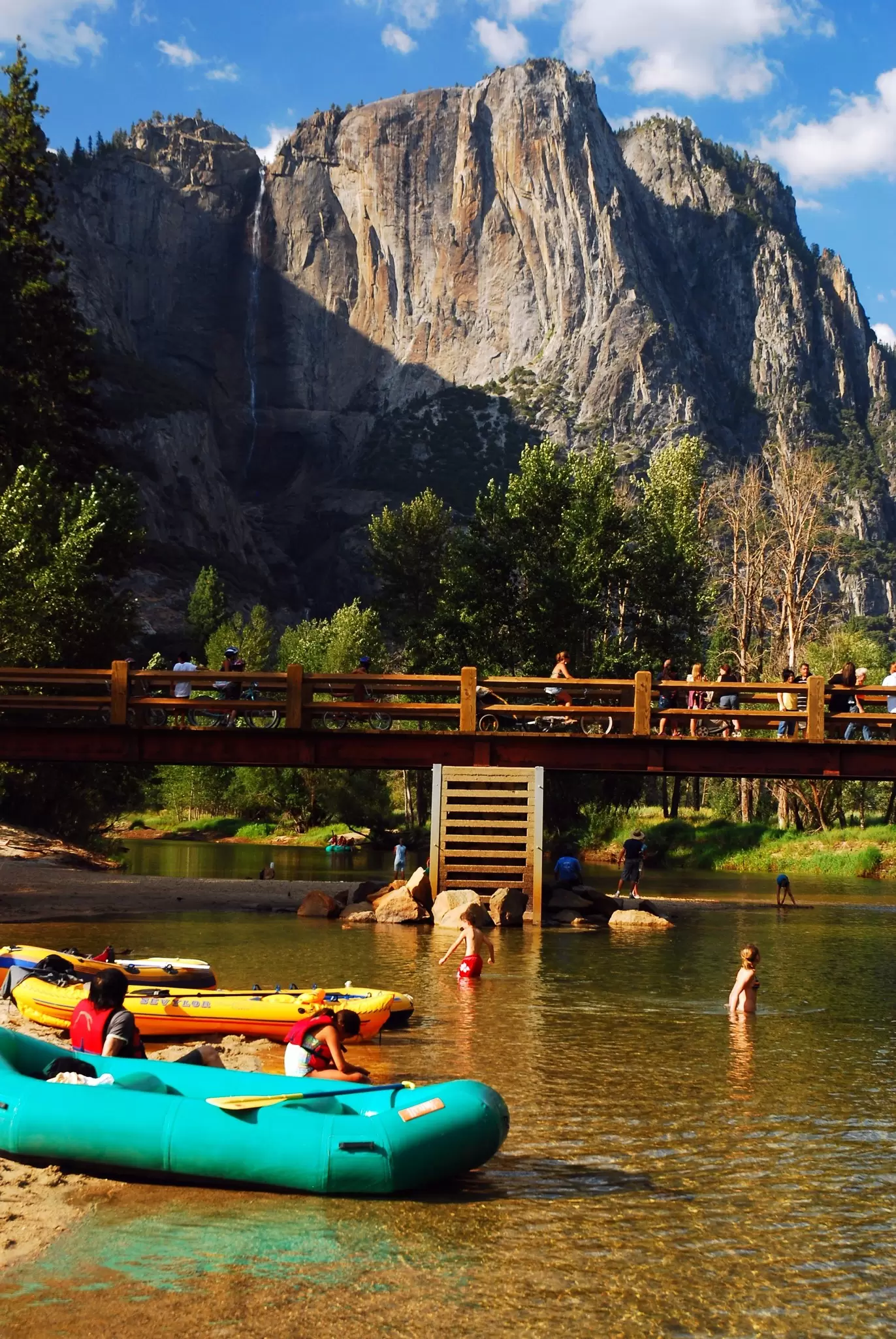 Inflatable rafts are brought to the shore, allowing people to wade in the Merced River in Yosemite National Park, California. 