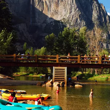 Inflatable rafts are brought to the shore, allowing people to wade in the Merced River in Yosemite National Park, California. 
