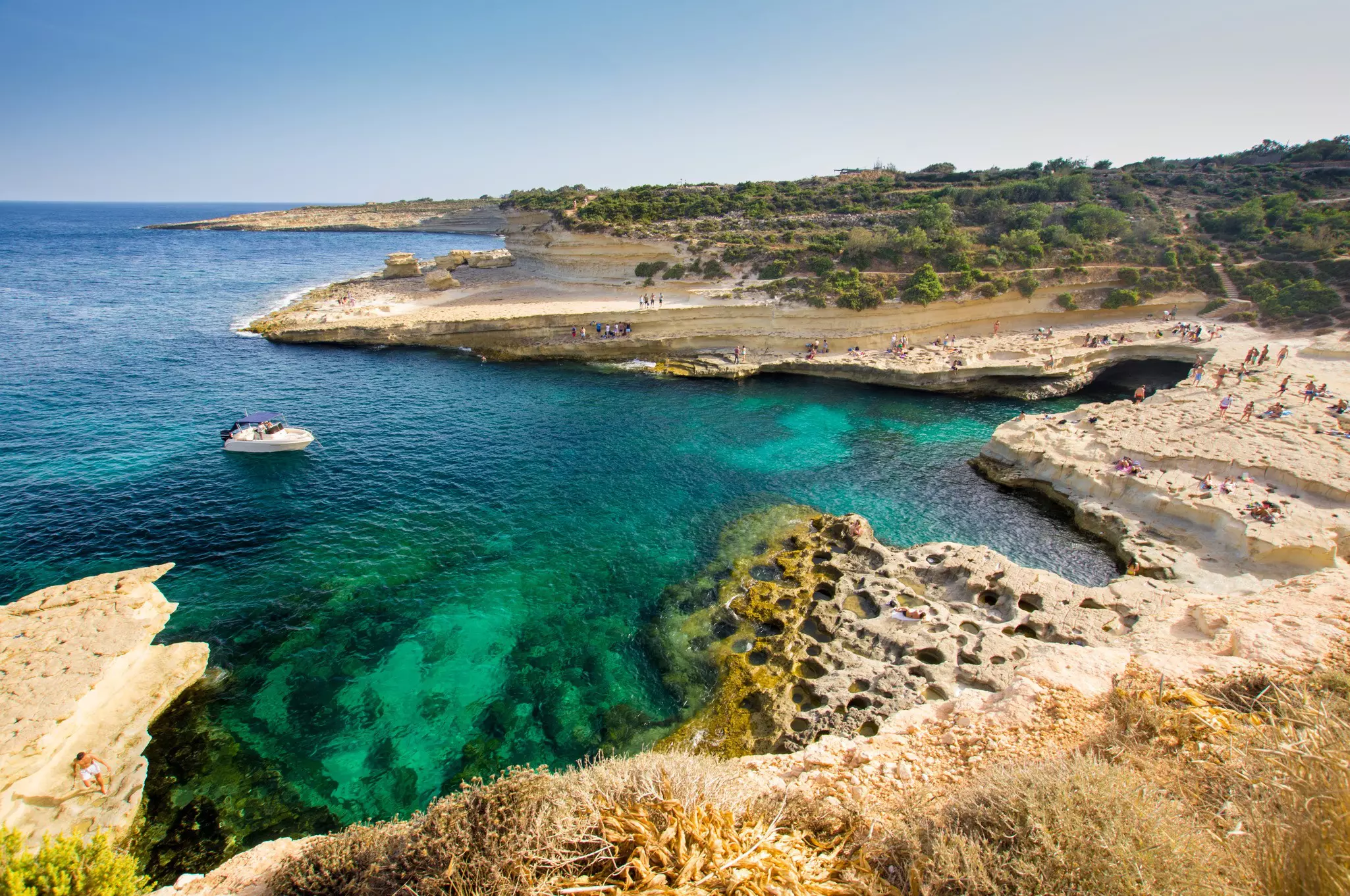 An inlet and natural swimming pool where people jump from the rocks into the water