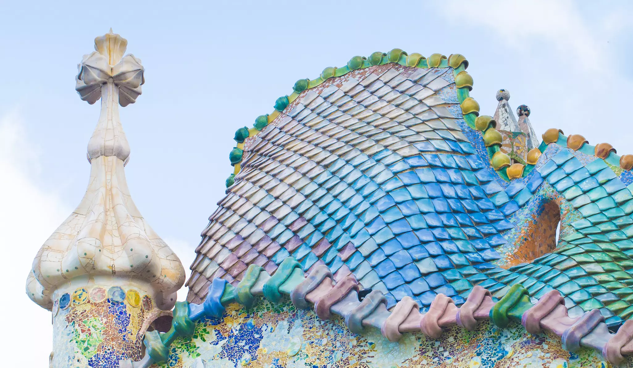 A close-up of shimmering tiles in blues, greens, pinks and yellows, creating an effect like fish scales or dragon skin