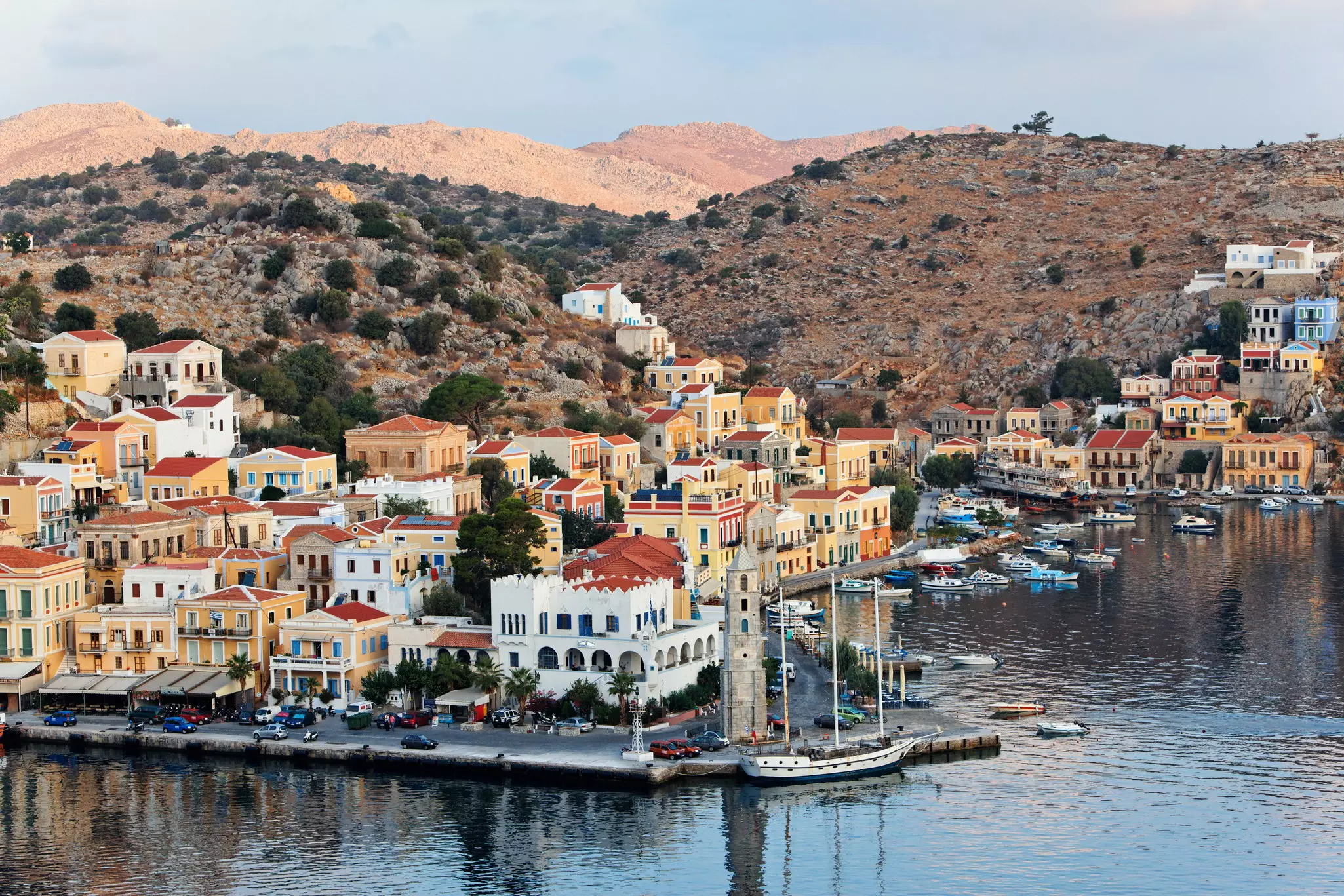 A sunny day in a seaside village with houses along the shore and built on the rocky hills.