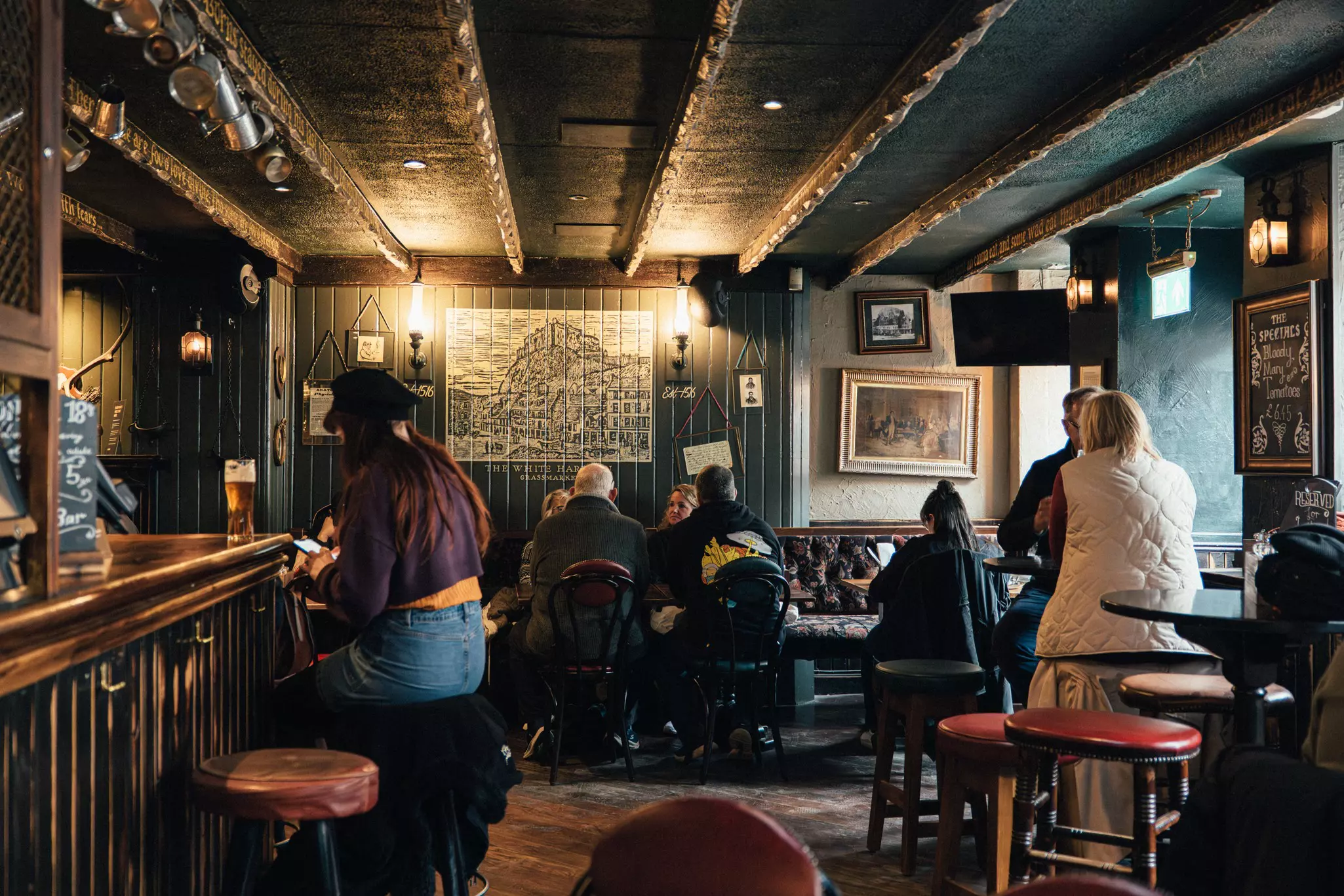 People drinking at the White Hart Inn, the oldest pub in Edinburgh, Scotland.