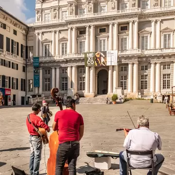 Piazza Matteotti with the historical palace Palazzo Ducale in the background, as a Romanian musicians group plays.