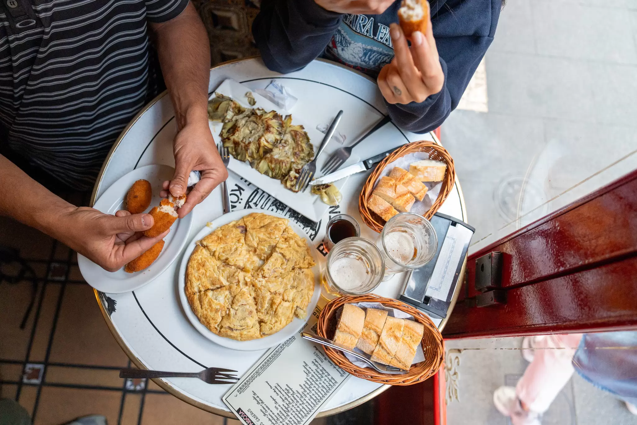 A table full of tapas and beer at Bodega de La Ardosa in Madrid, Spain.