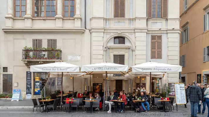 People enjoying outdoor seating at a restaurant and bar