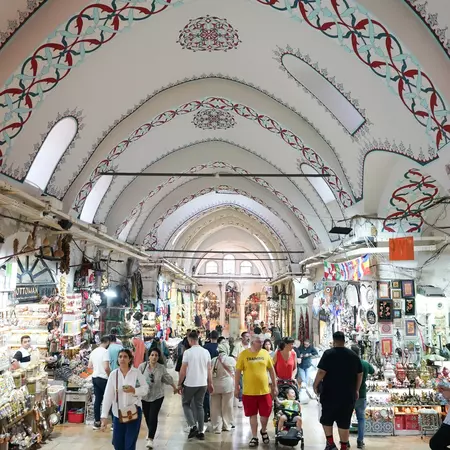 People shopping in the Grand Bazaar with its ornate arches.
