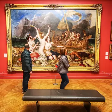 Visitors walk by paintings in the famous Manchester Art Gallery, Manchester, England, UK