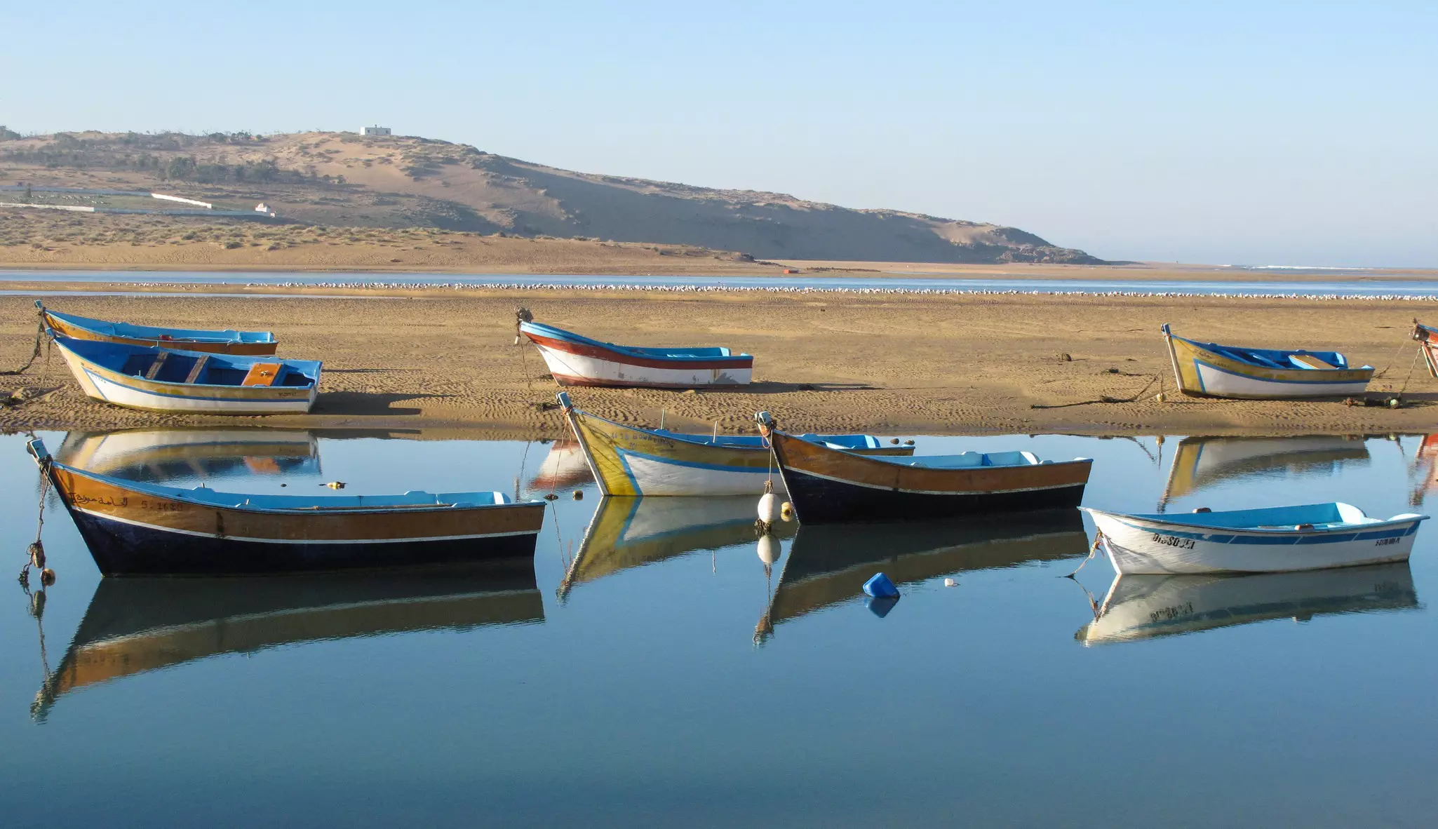 Traditional fishing in Morocco, at the port of Moulay Bousselham. A huge fleet of traditional wooden pirogues painted in bright colors. Merja Zerga lagoon is a quiet place with traditional boat.
