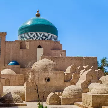 Mausoleum of Pahlavan Mahmoud, medieval poet and pahlevani champion. One of main historical sites in Khiva, Uzbekistan. Building is surrounded by small ancient graves from different centuries; Shutterstock ID 2083392193;