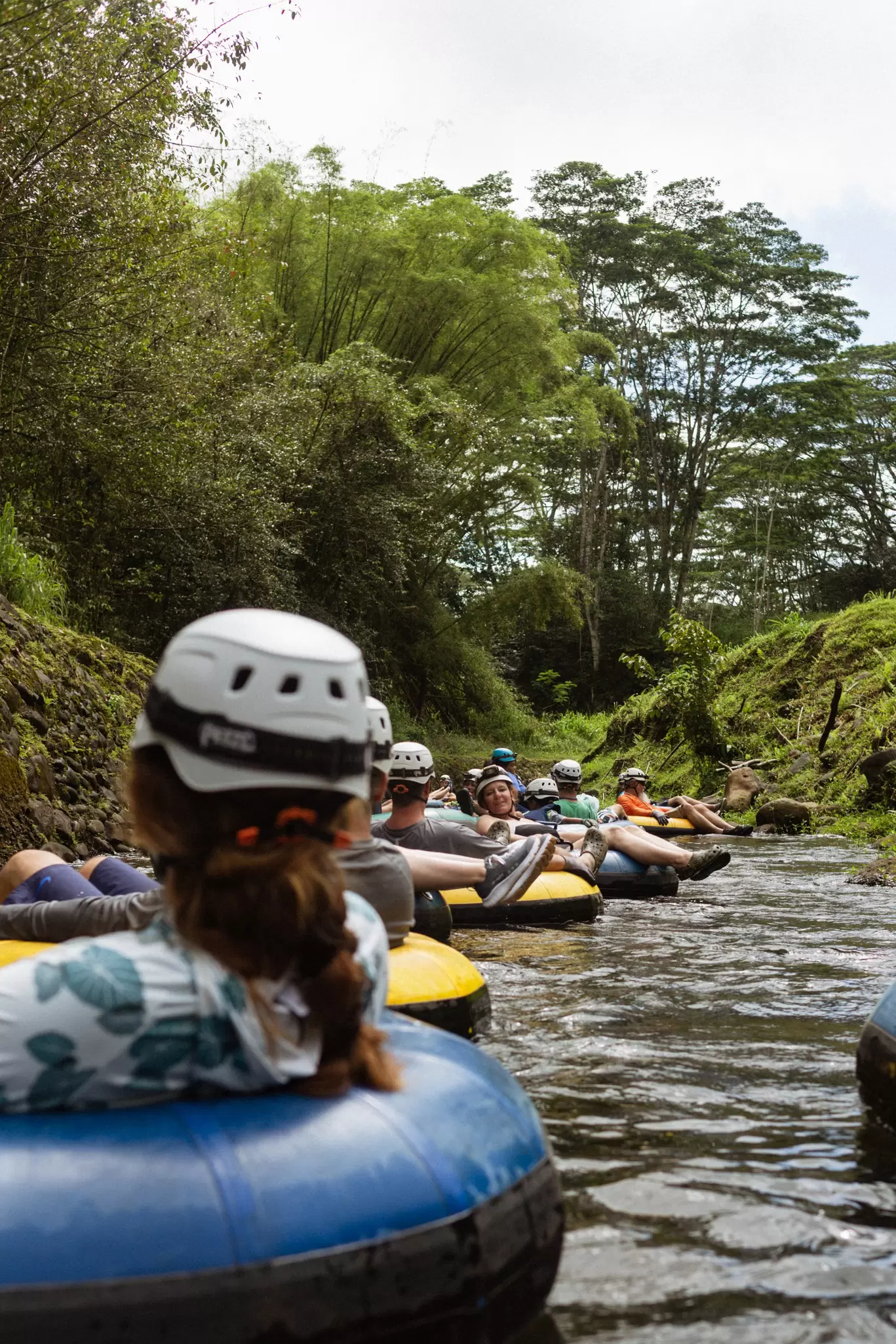 A group of people floating down a river in colorful intertubes. 