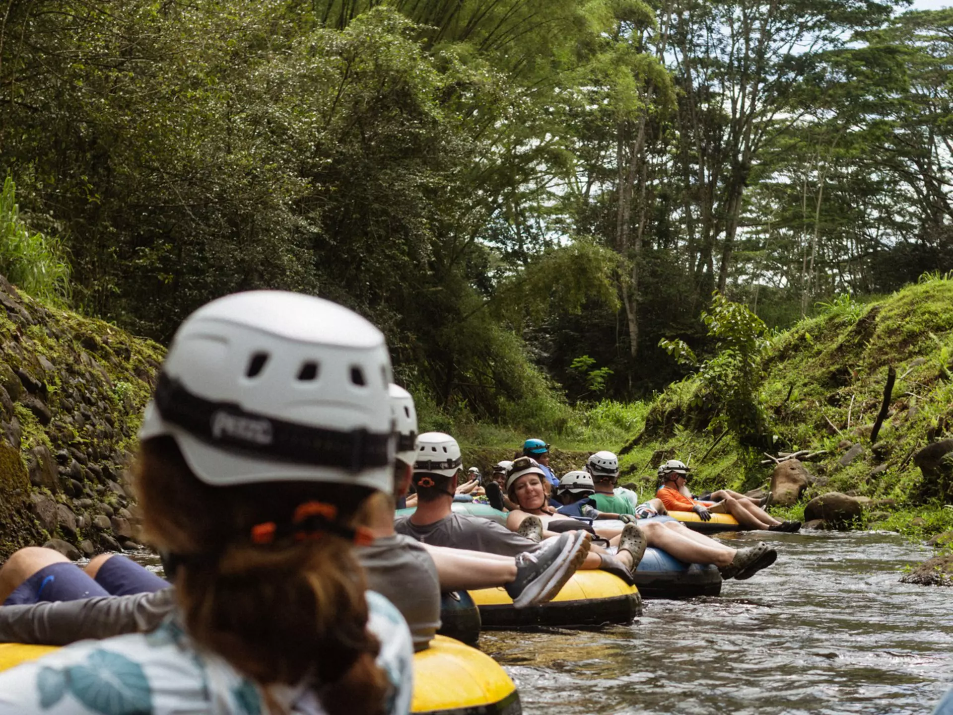 A group of people floating down a river in colorful intertubes. 