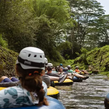 A group of people floating down a river in colorful intertubes. 