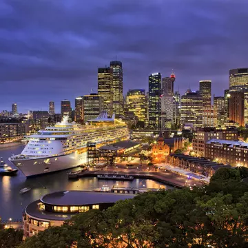 A giant cruise ship docked at Sydney harbour with the city skyline at night.
266033717
cruise, tower, destination, australia, liner, travel, urban, landmark, quay, night, luxury, port, twilight, modern, ships, cloudy, architecture, city, blue, terminal, colorful, panorama, sunset, illumination, sky, house, sea, sydney, water, bridge, voyager, giant, lights, cityscape, nsw, cbd, harbour